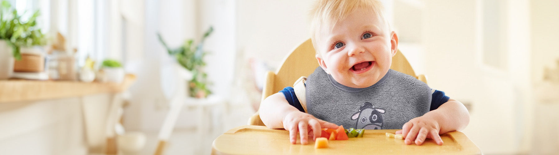 Kind mit Lätzchen aus Bio Baumwolle