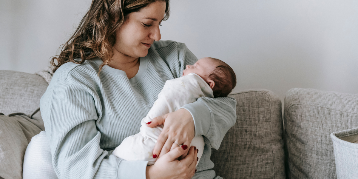 Mama hält schlafendes Baby auf ihrem Arm