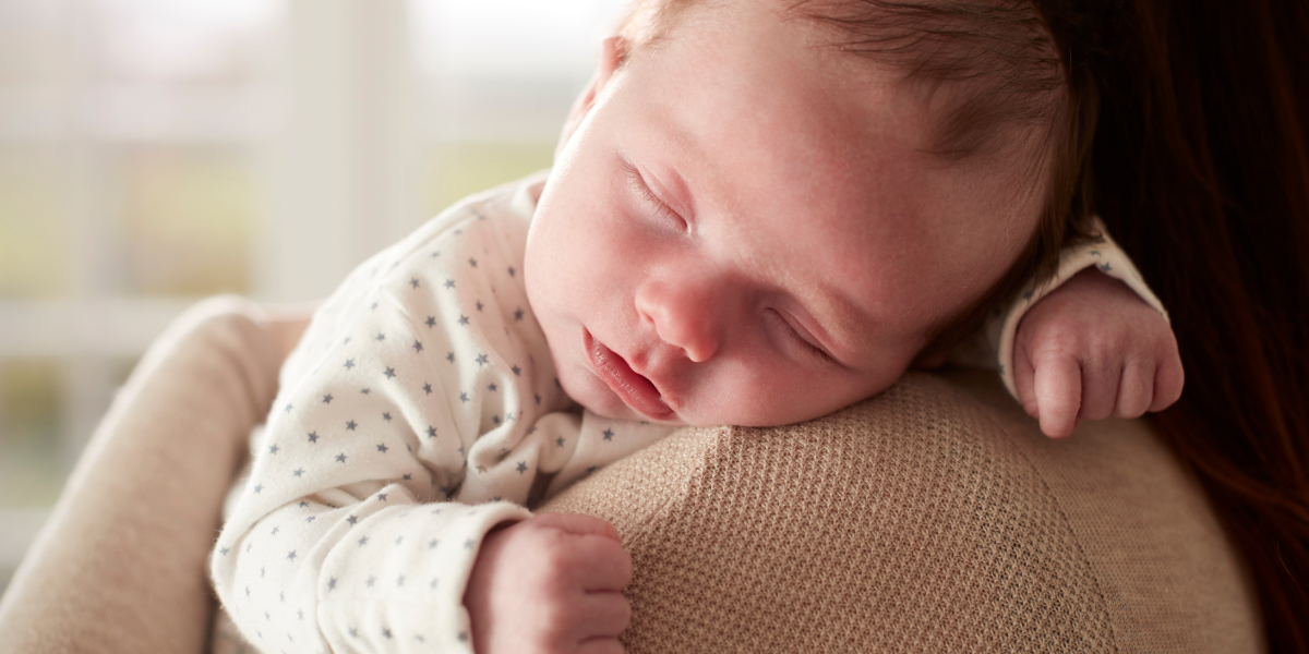 Baby schläft auf der Schulter