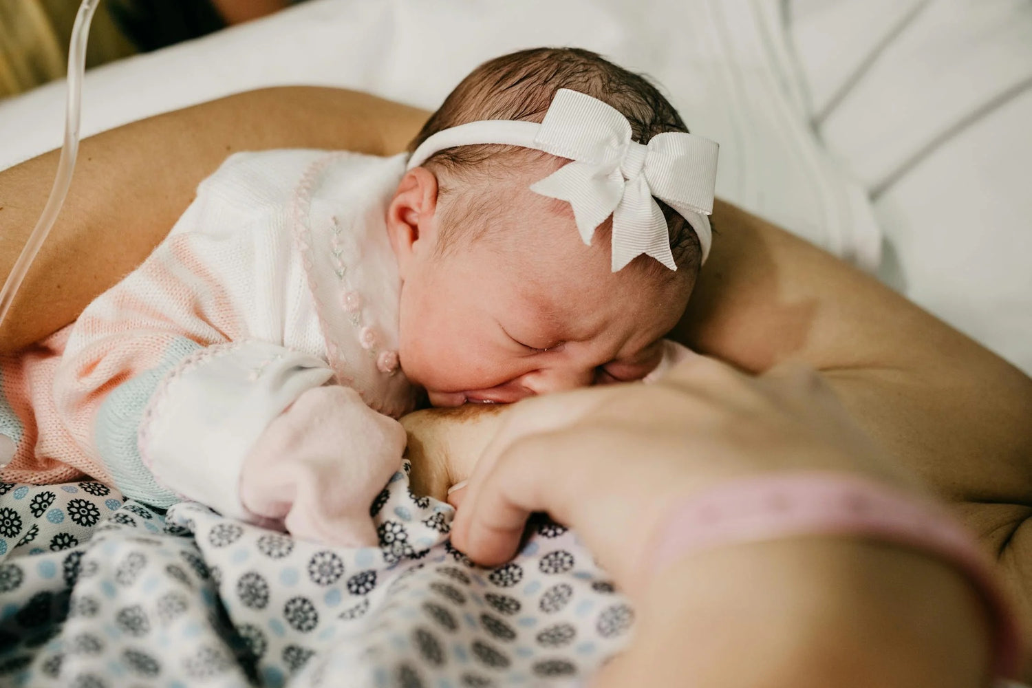 Eine Frau hält ein neugeborenes Baby, das friedlich in ihren Armen schläft, und verkörpert damit mütterliche Zuneigung.