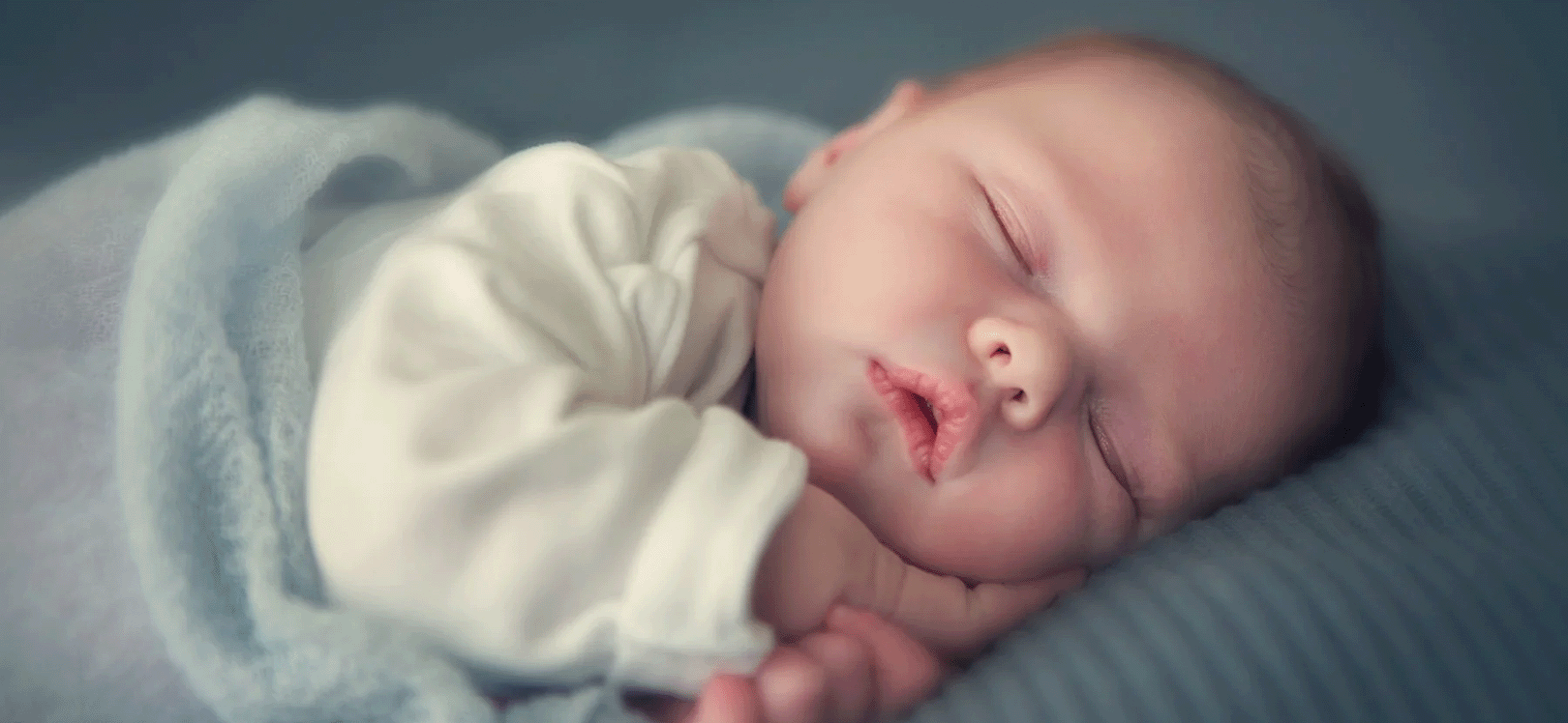 Schlafendes Baby auf mit blauer Decke